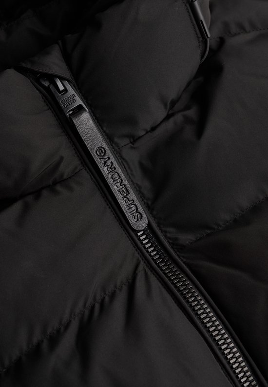 Detail van de ritssluiting van een zwarte Superdry pufferjas met logo.