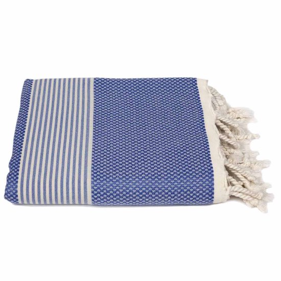 Donkerblauwe hamamdoek opgevouwen, met witte strepen aan de linkerkant en een wit patroon aan de rechterkant. Franjes zichtbaar.