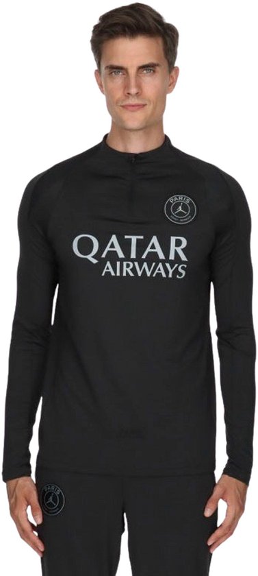 Man met zwart PSG trainingsjack, met 'QATAR AIRWAYS' logo op borst.