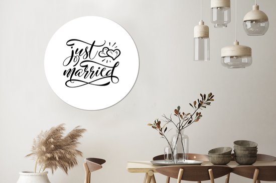 Un cercle mural avec le texte 'just married' en écriture élégante, avec deux cœurs au-dessus.