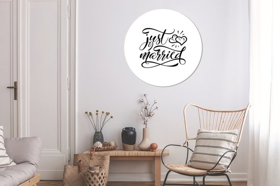 Un cercle mural avec le texte 'just married' en écriture élégante, avec deux cœurs au-dessus.