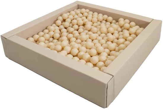 Beige ballenbak gevuld met crème-kleurige ballen, vanuit een hoge hoek gefotografeerd.