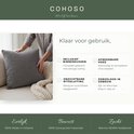 Een vrouw met een donkergrijs teddy kussen op een bank. Tekst: 'Klaar voor gebruik', 'Inclusief binnenkussen', 'Afneembare hoes', 'Zorgeloos in gebruik'.