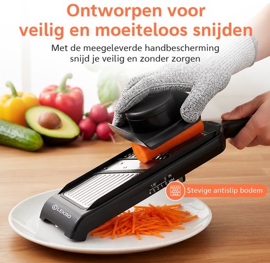 Mandoline snijder snijdt wortel in julienne. Handschoen beschermt hand. Zwarte mandoline met antislip bodem.