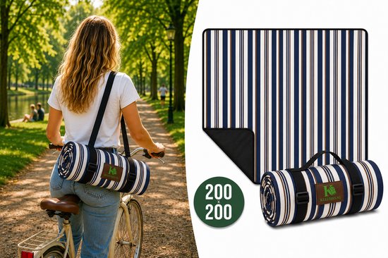 Une femme fait du vélo avec un tapis de pique-nique enroulé rayé bleu, blanc et brun sur le dos. Le tapis est déplié à côté du vélo.