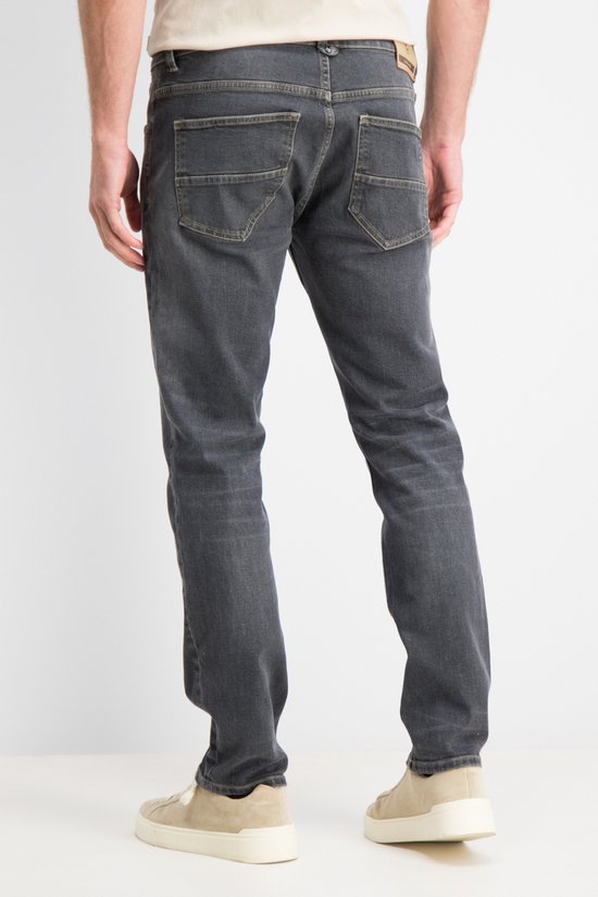 Achterkant van een Gabbiano Arctic relaxed jeans in antraciet stone wash met twee achterzakken en beige sneakers.