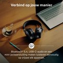 Zwarte Sennheiser koptelefoon op een houten tafel naast een laptop en een kopje koffie. Verbinding via Bluetooth, USB-C of mini-jack.