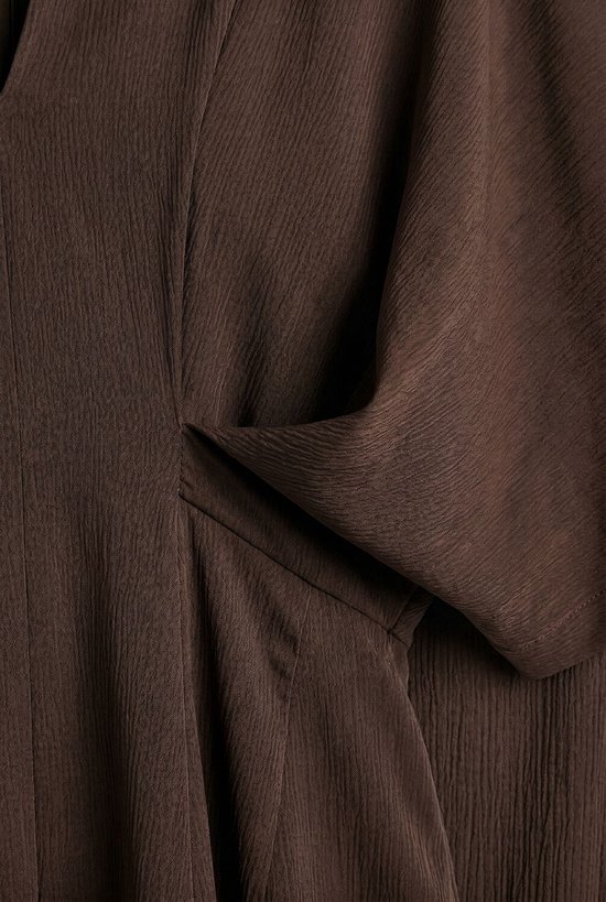 Détail de tissu marron texturé avec drapés.
