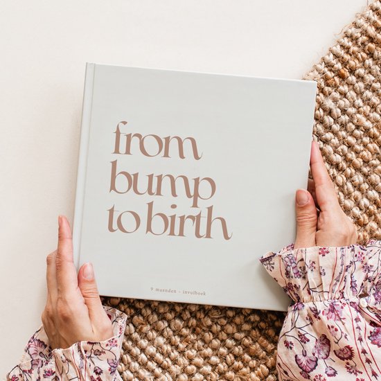Licht beige omslag 'from bump to birth' met tekst. Van '9 maanden - invulboek'. In handen van een persoon met bloemenprint.