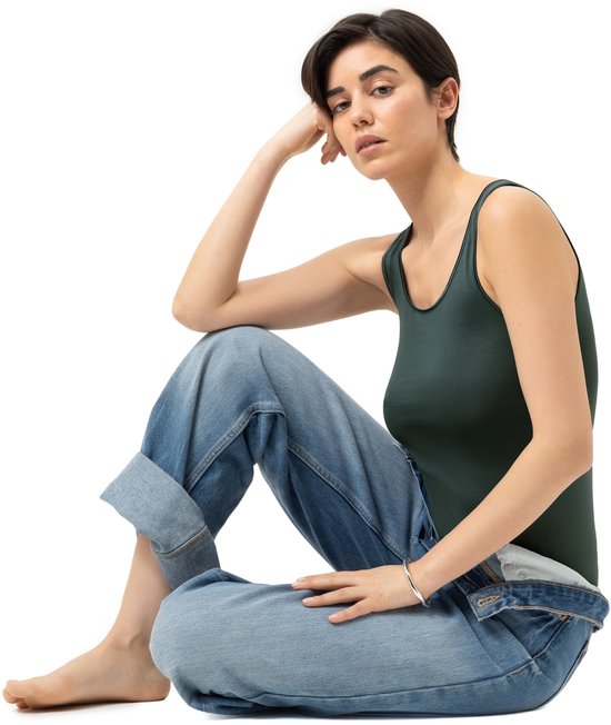 Donkergroene tanktop gedragen met een jeans.