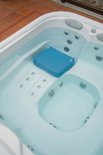 Blauw spa zitkussen in een bubbelbad, met bubbels die uit de jets komen.