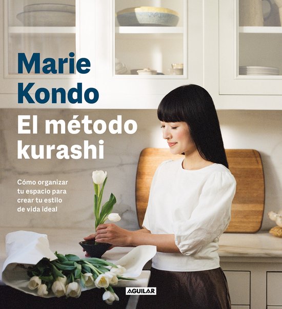 Een Aziatische vrouw met een witte top en bruine rok rangschikt tulpen in een vaas in een keuken. "Marie Kondo El método kurashi"