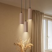 Drie beige hanglampen met verticale ribbels, hangend aan zwarte snoeren.