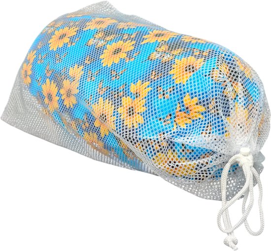 Cilindrisch kussen met bloemenprint in een wasnet, op zwarte achtergrond.