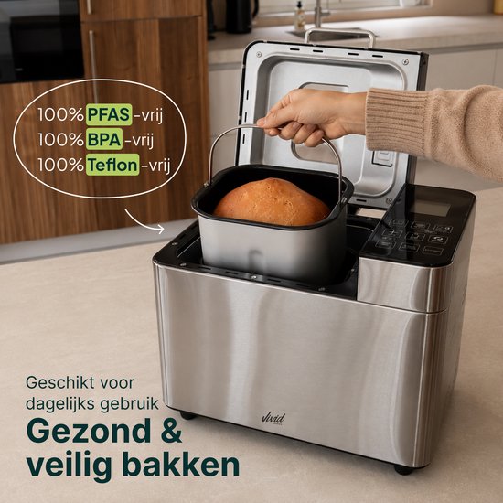 Hand haalt een brood uit een zilverkleurige broodbakmachine.