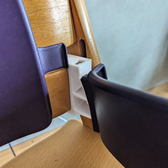 Witte adapter bevestigd aan een houten Tripp Trapp kinderstoel met paarse zitting.