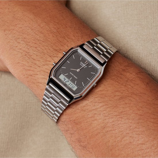 Zilverkleurig metalen horloge met zwart vierkant display om de pols van een man. Digitale tijd 4:21'17.
