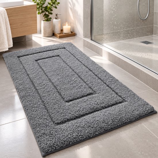 Tapis de bain gris foncé avec des motifs rectangulaires concentriques et une texture moelleuse.