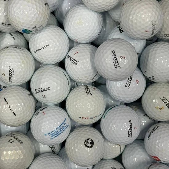 Stapel gebruikte witte Titleist golfballen, met verschillende nummers en logo's.