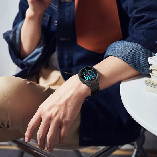Een persoon draagt een zwarte smartwatch met een zwart horlogebandje om de pols.