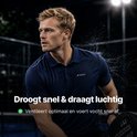 Man in donkerblauw poloshirt met witte accenten op een sportveld.