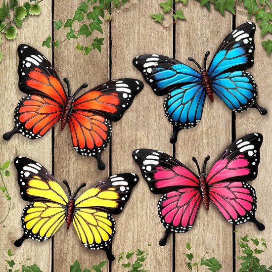Vier metalen vlinders op een houten achtergrond, in de kleuren oranje, blauw, geel en roze.