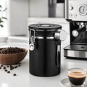 Zwarte RVS koffiebewaarpot in een keukenomgeving, naast een espressomachine, een kom koffiebonen en een kopje espresso.