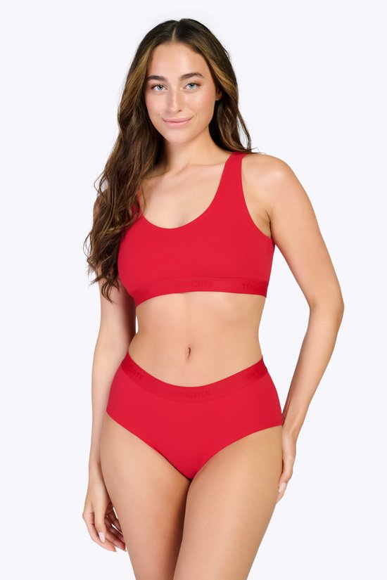 Een vrouw van voren gezien, draagt een rode ten Cate beha top en bijpassende slip.