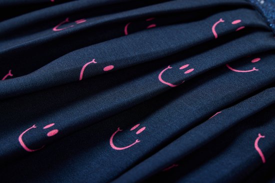 Donkerblauwe rok met plooien en een print van roze lachende gezichtjes.