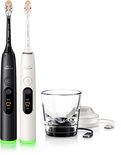 Zwarte en witte Philips Sonicare elektrische tandenborstels met oplaadglas.