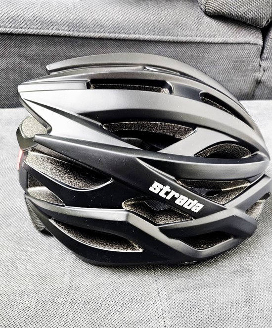 Zijzicht van een zwarte Strada fietshelm met ventilatieopeningen en het witte logo 'strada'.