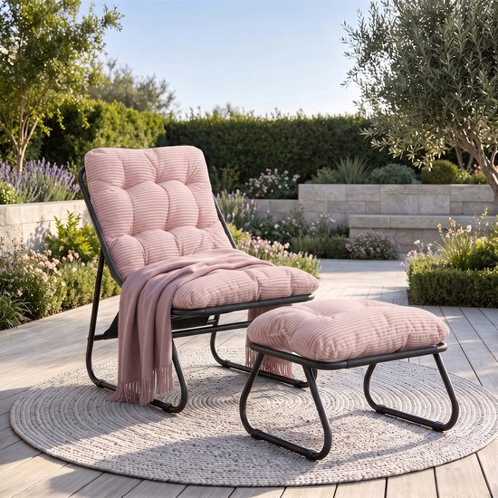 Fauteuil rose avec repose-pieds en tissu côtelé sur un tapis rond dans un jardin. Un plaid rose est posé sur le fauteuil.
