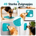Honden likken aan een blauwe likmat met 49 zuignapjes, bevestigd aan een kast.