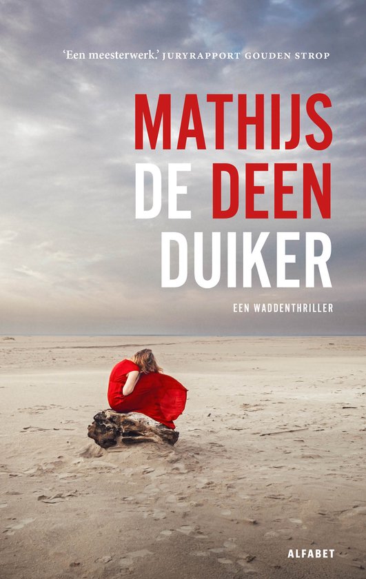 Een vrouw in een rode jurk zit op een boomstronk op het strand met haar rug naar de kijker.
