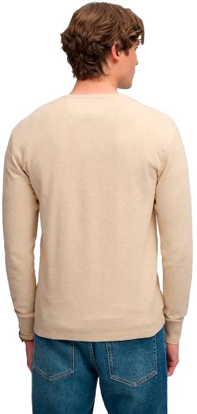 Achterkant van het model in een beige waffle grandad-top met lange mouwen en een blauwe jeans.