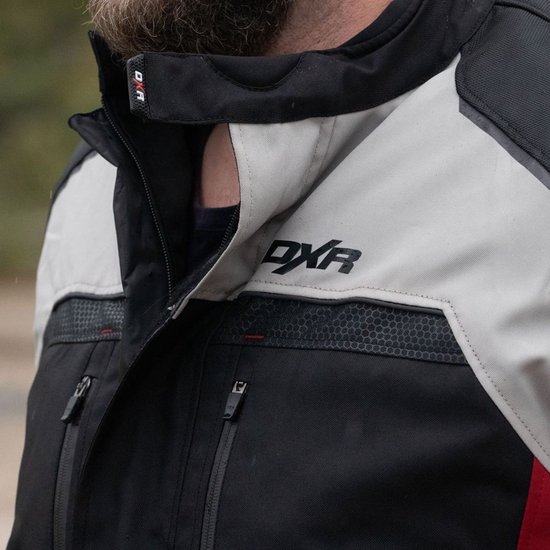 Detail van de kraag van een zwarte, lichtgrijze en rode motorjas met "DXR" logo.