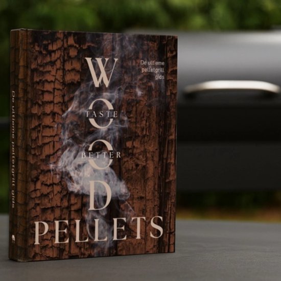 Het boek "Wood pellets taste better - de ultieme pelletgrill gids" op een tafel, met een barbecue op de achtergrond.