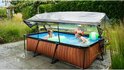 Rechthoekig zwembad met houtlook en afdak, kinderen spelen erin met speelgoed.