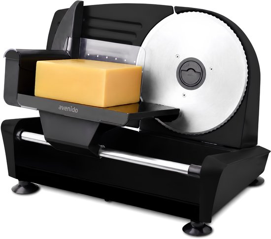 Zwarte snijmachine met een blok geel kaas.