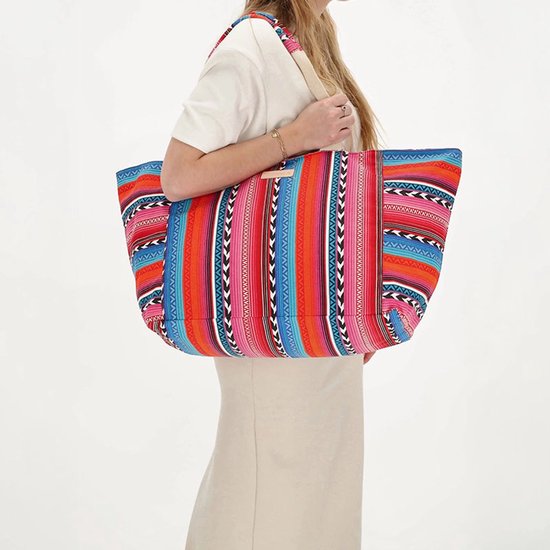 Grote strandtas met verticale strepen in fuchsia, blauw, oranje, zwart en wit. Schouderbanden van beige stof.