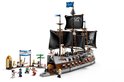 Een LEGO piratenschip met zwarte zeilen, veel speelfiguren, en een drijvende poort met 'MARINE VICTORY DAY' banner.