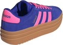 Zijaanzicht van een blauwe Adidas VL Court Bold damessneaker met roze strepen en roze hiel, op een bruine zool.