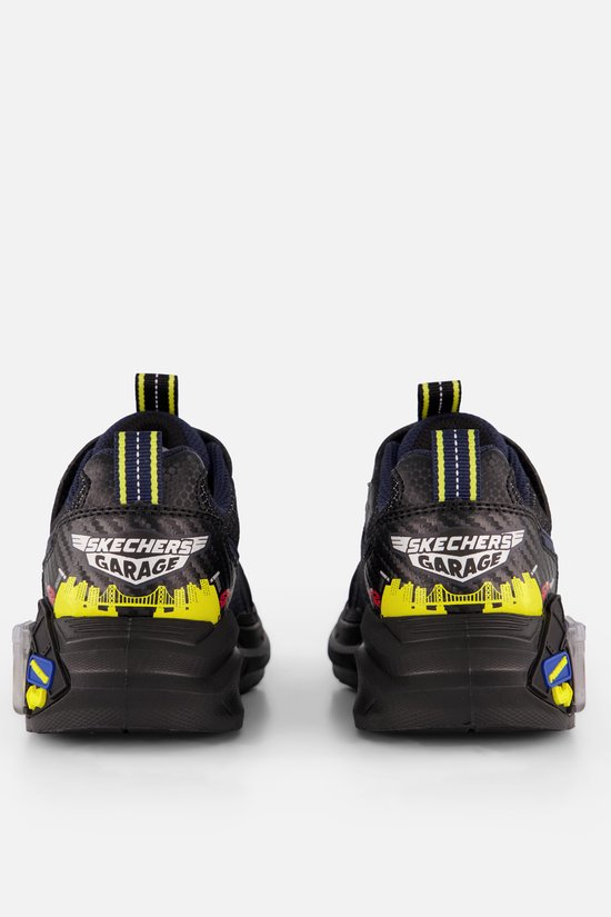 Achterkant van blauwe sneakers met "SKECHERS GARAGE" logo, stadsgezicht en lichtjes.