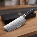 Couteau de chef à motif damassé avec manche noir, à côté d'une boîte cadeau noire Hi Nature.