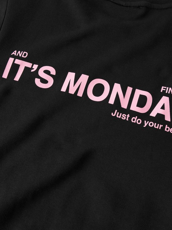 Detail van een zwarte sweater met de roze tekst 'AND FINALLY IT'S MONDAY Just do your best'.