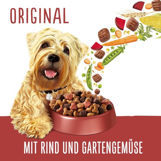 West Highland White Terrier met een kom vol hondenbrokken, met "Original" en "Mit Rind und Gartengemüse" tekst. Brokken vliegen uit een kom met wortels en erwten.