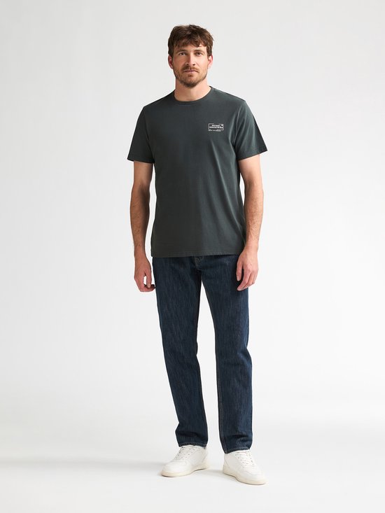 Man met donkergrijs t-shirt en donkerblauwe jeans.