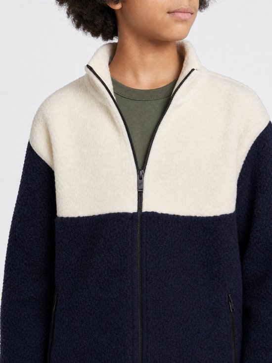 Close-up van het donkerblauwe en off-white teddyjack met rits en een olijfgroene voering.