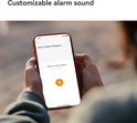 Close-up van een smartphone met de interface om een nieuwe ringtone op te nemen, met de tekst 'Customizable alarm sound'.
