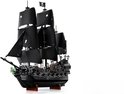 Un bateau pirate LEGO noir avec 3 grandes voiles noires et une figure de proue verte.